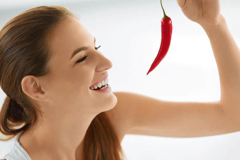 Picture of a healthy women looking at a healthy Chilli